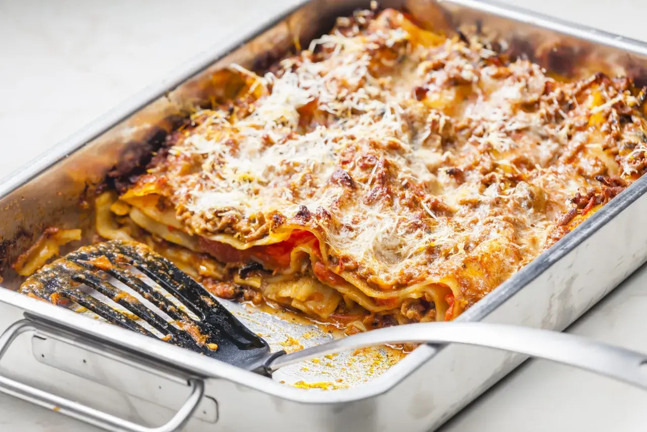 Lasagnes généreuses dans un plat, prêtes à servir. Une quantité parfaite pour régaler 12 personnes.