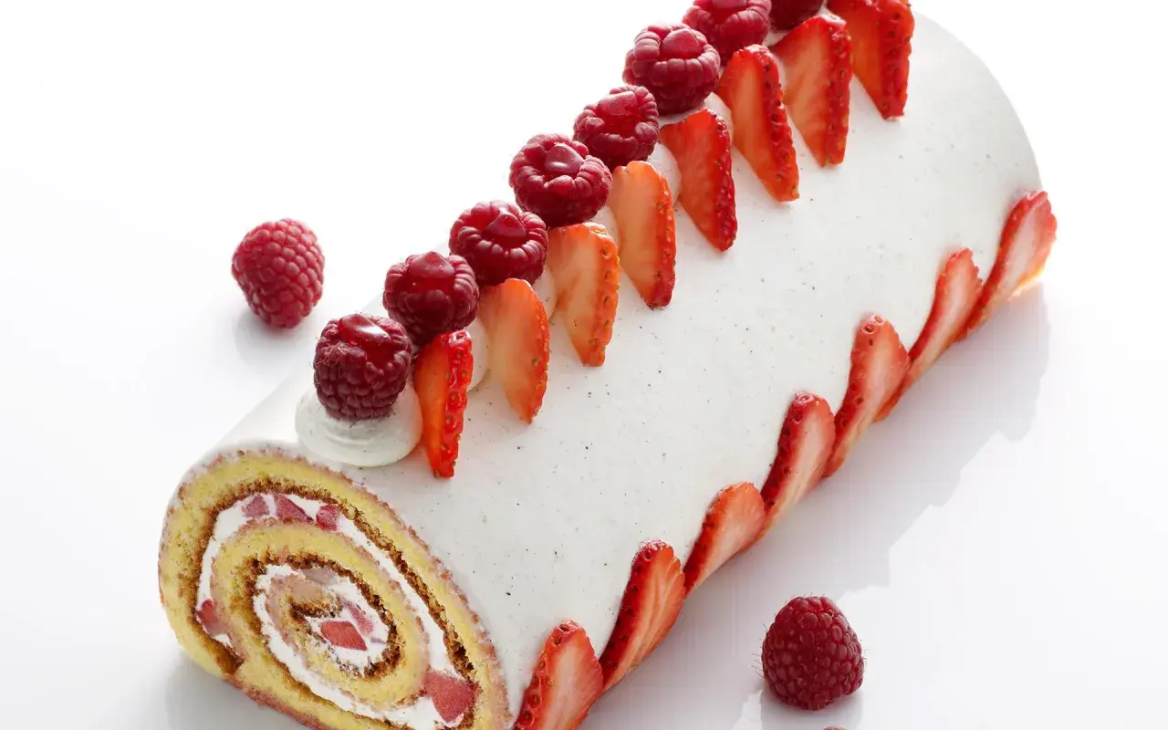 Un délicieux roulé fraise mascarpone, orné de fruits rouges frais et de fines tranches de fraises, invite à la gourmandise.