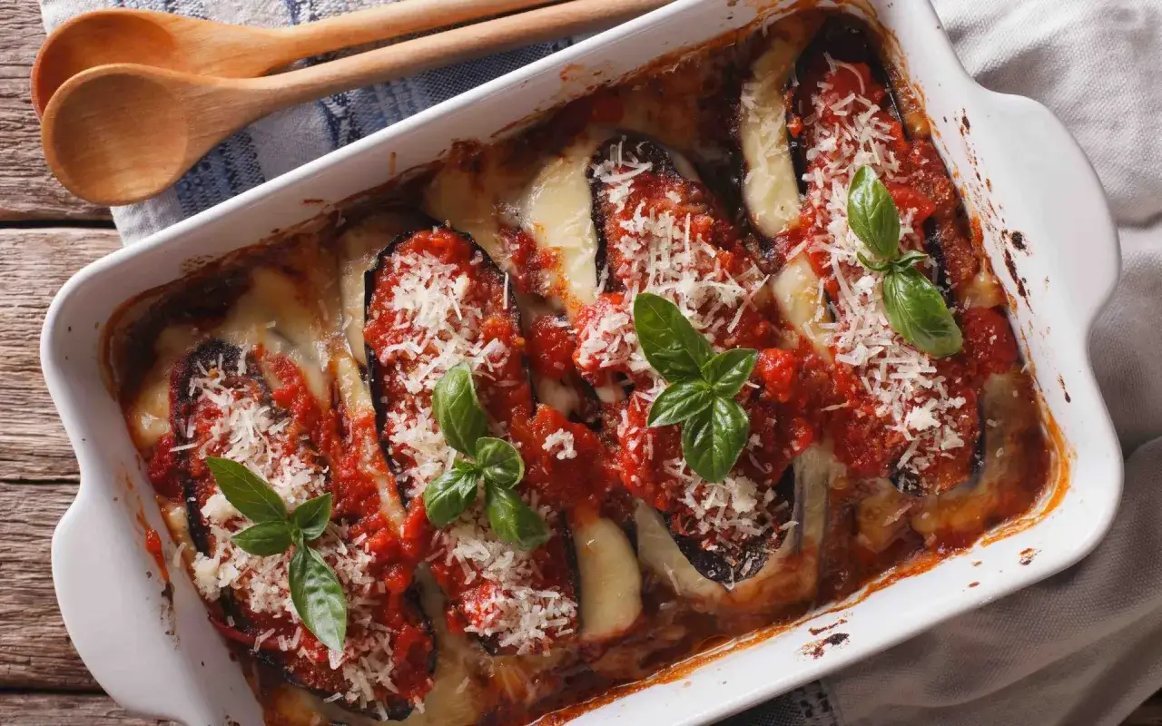 Aubergine à la parmesane, un plat gratiné aux aubergines, sauce tomate, mozzarella fondante et basilic frais, prêt à être dégusté.