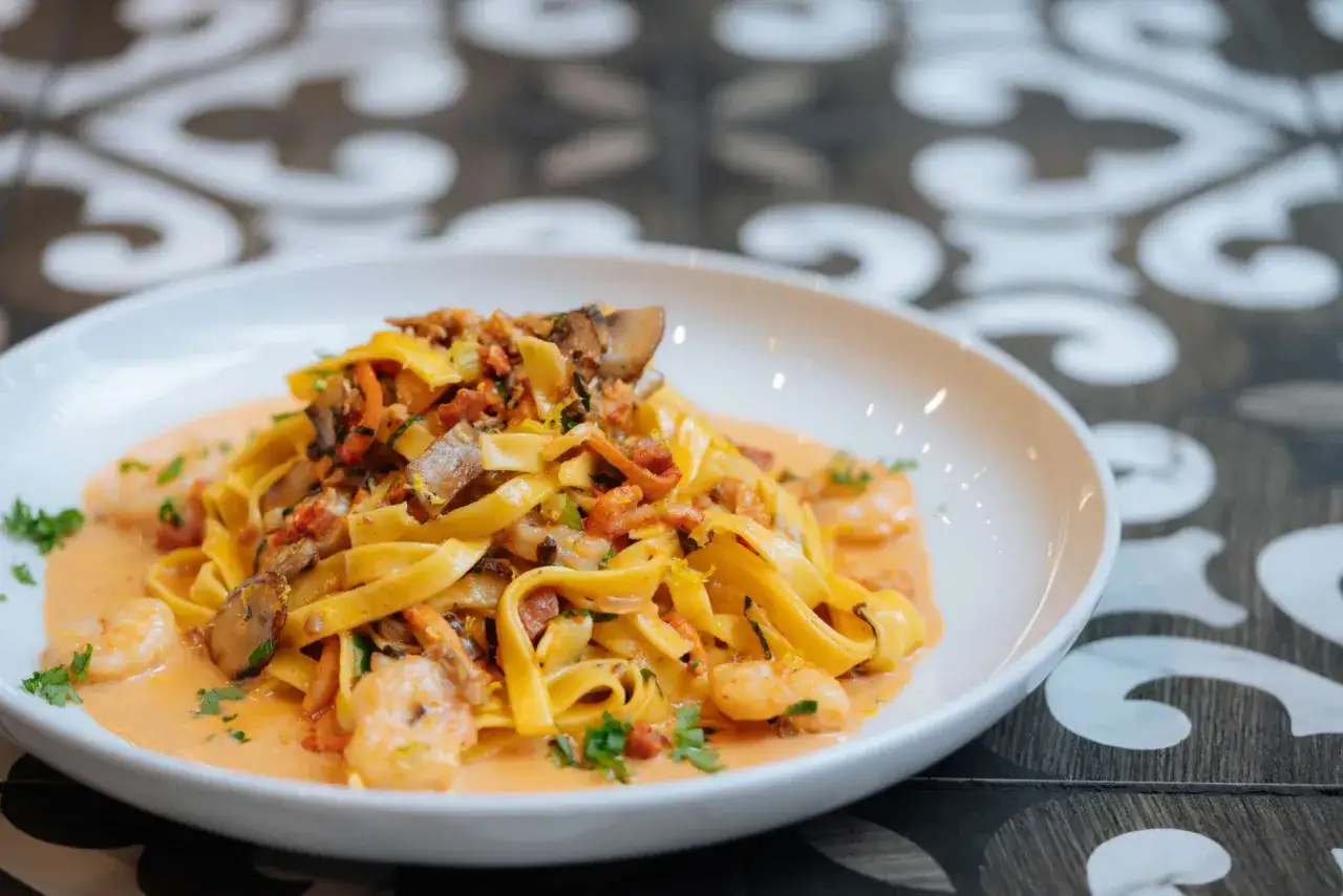 Assiette de pâtes aux crevettes et champignons, nappées d'une sauce crémeuse. Un délice de pâtes au homard revisité.
