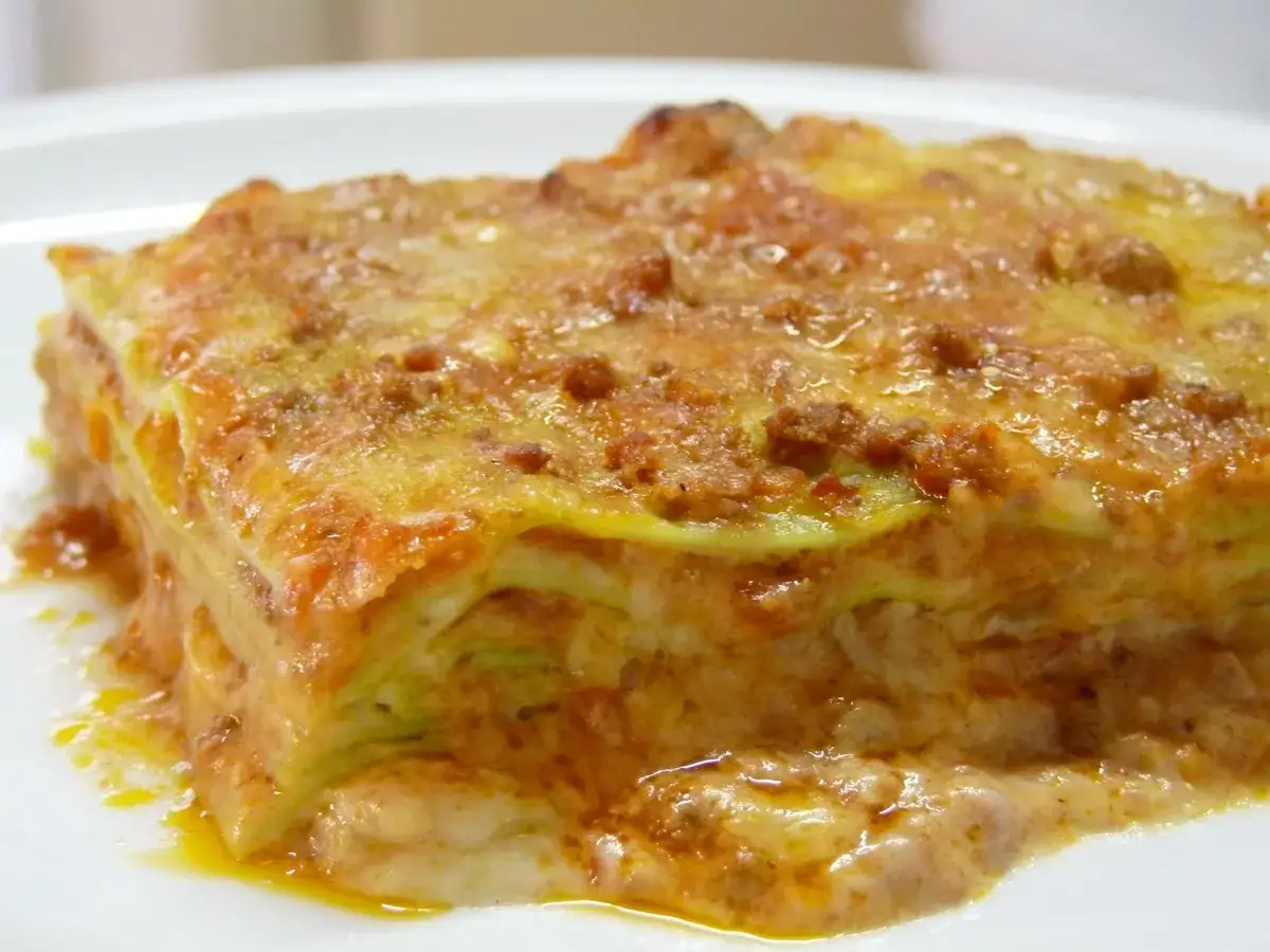 Une part de lasagne, riche en couches de p&acirc;tes, sauce bolognaise et b&eacute;chamel, &eacute;voque la lasagne origine italienne.