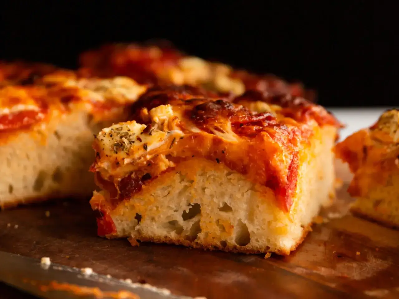 Tranches de pizza généreuses, garnies de sauce tomate et de fromage fondant, prêtes à être dégustées.