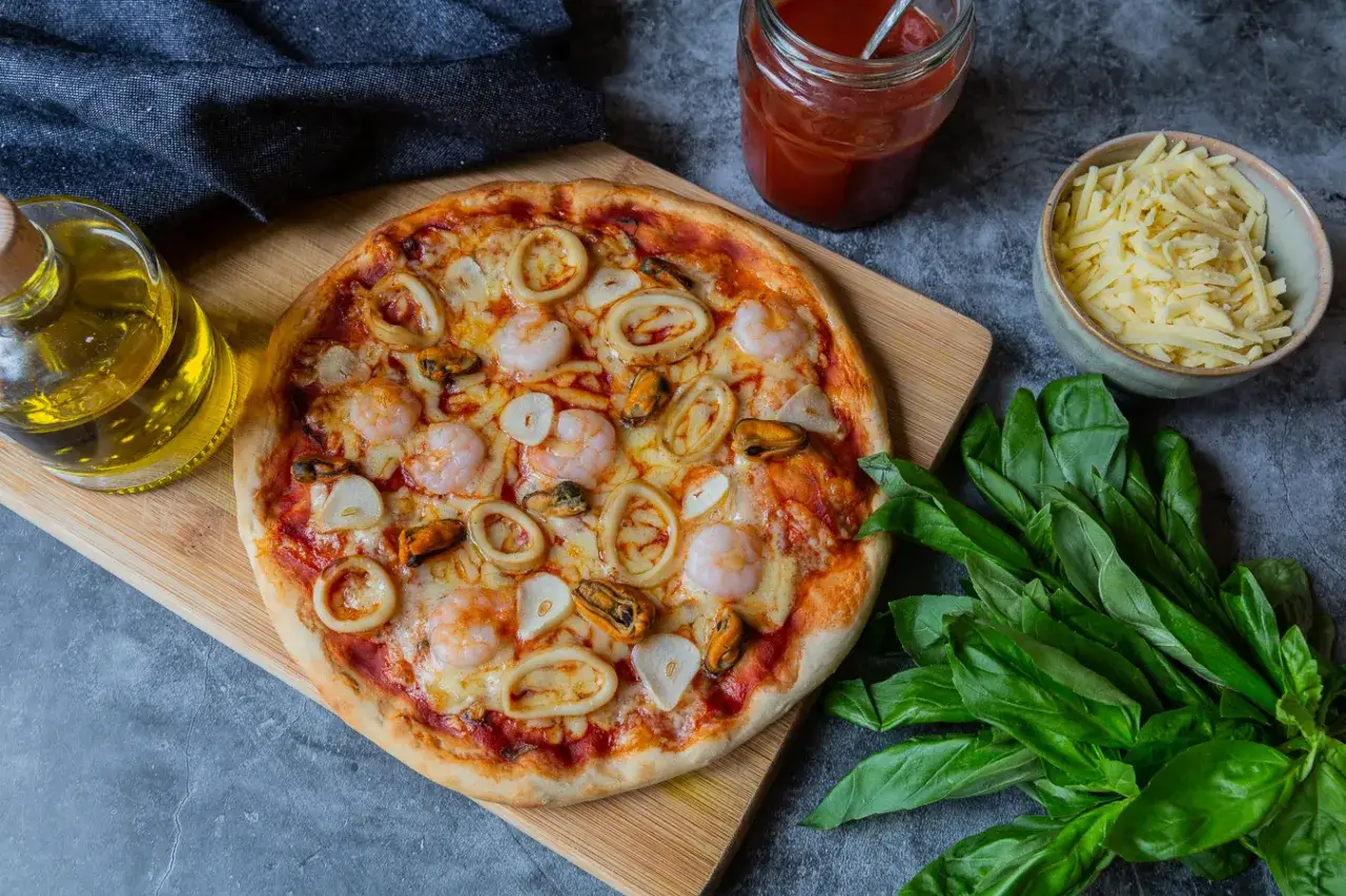 Une délicieuse pizza fruit de mer, garnie de crevettes, calamars et moules, prête à être dégustée.