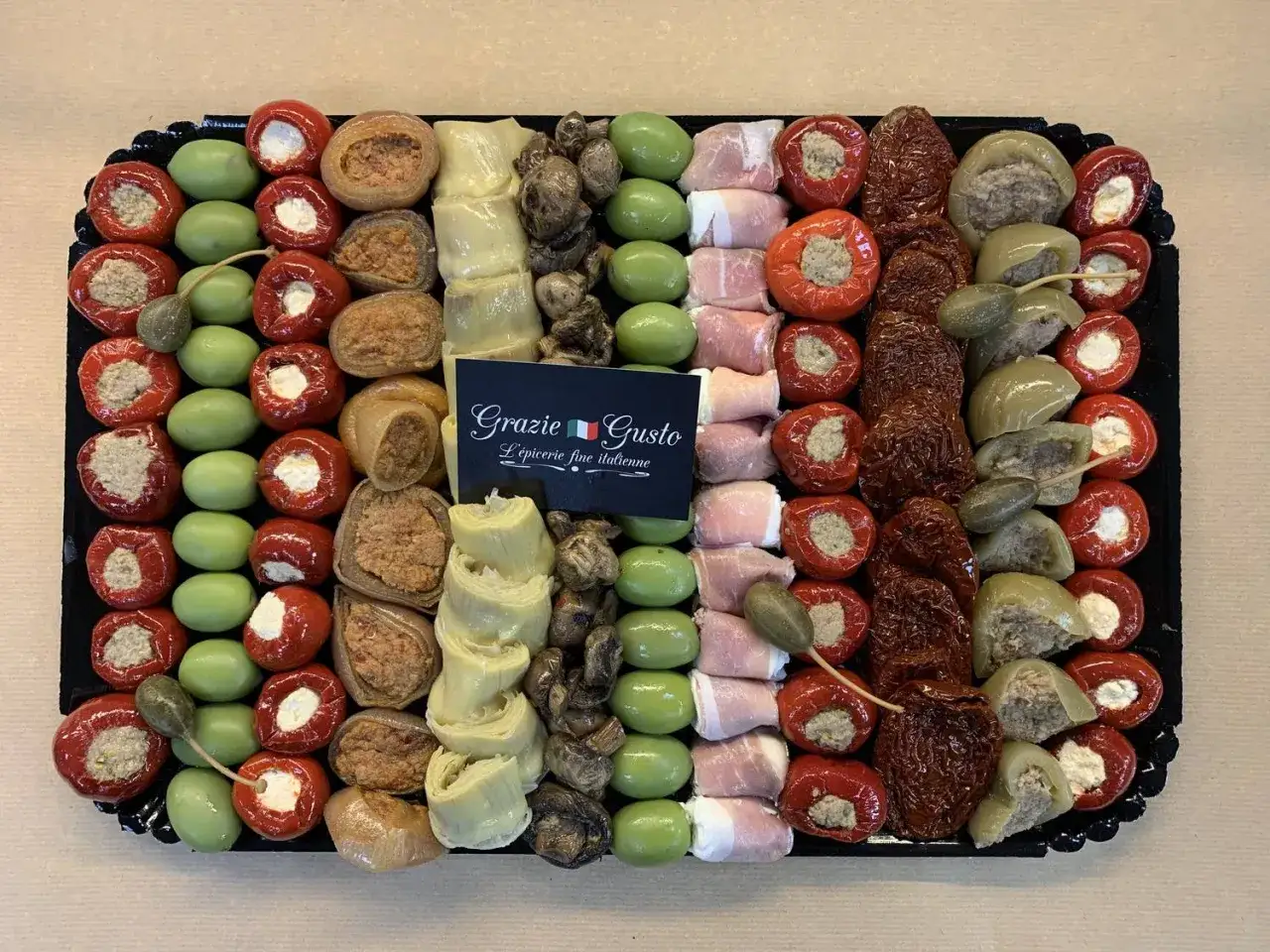Plateau de recette antipasti italien facile : poivrons farcis, olives, artichauts, tomates séchées, prosciutto. Un délice pour l'apéritif !