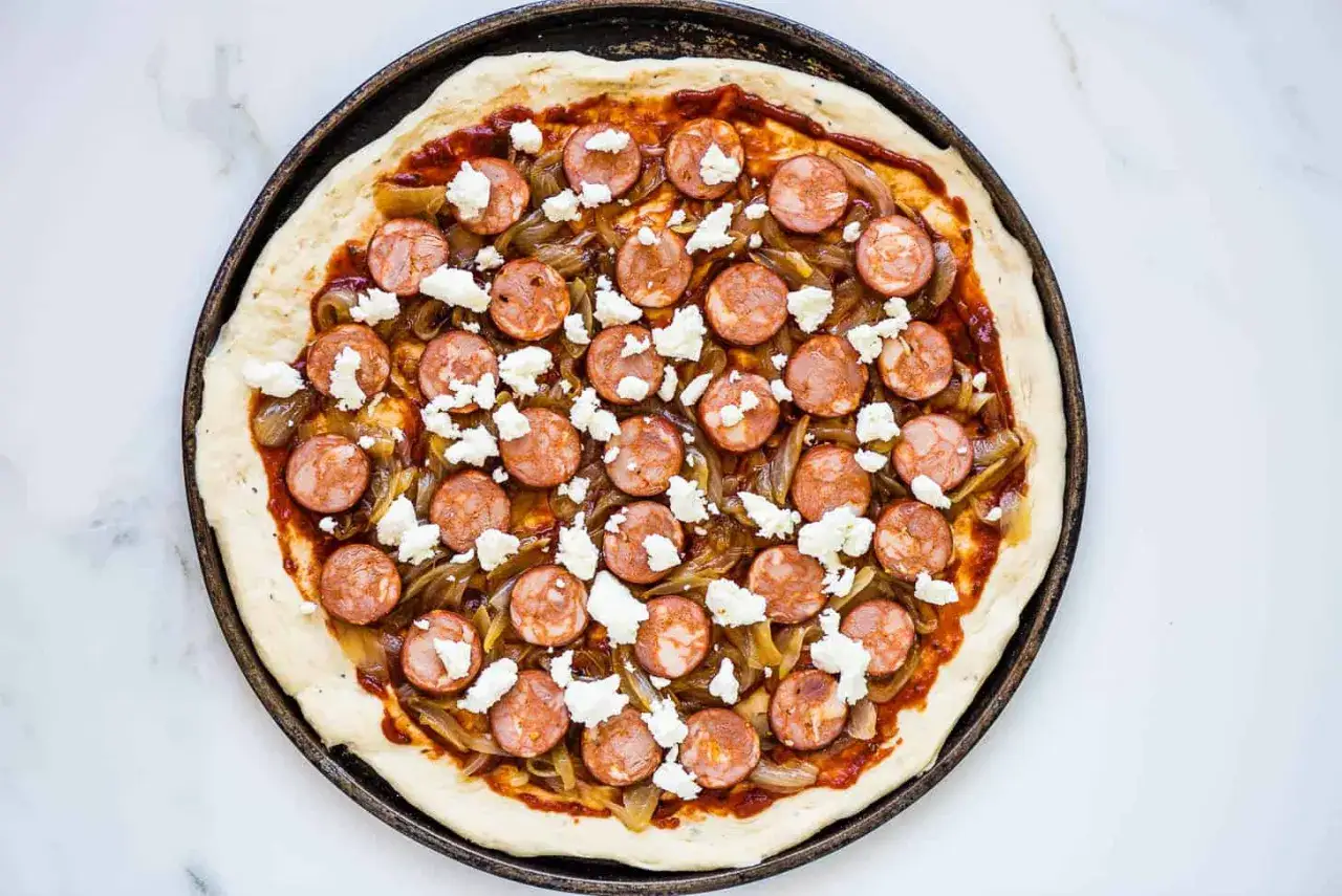 Pizza maison garnie de rondelles de chorizo, oignons caramélisés et éclats de fromage blanc.
