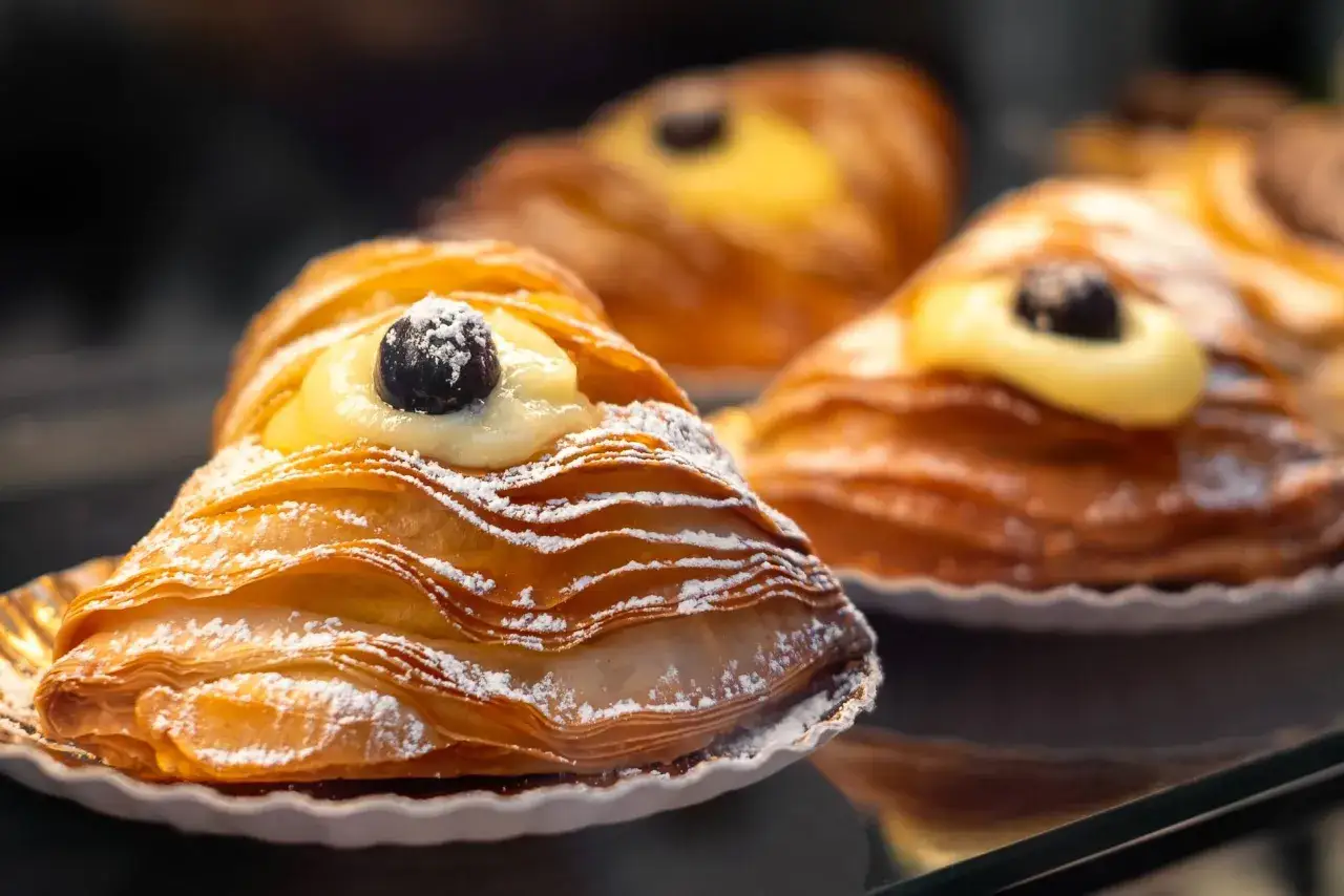 P&acirc;tisserie italienne typique : feuillet&eacute; dor&eacute; garni de cr&egrave;me p&acirc;tissi&egrave;re et d'une cerise, saupoudr&eacute; de sucre glace.