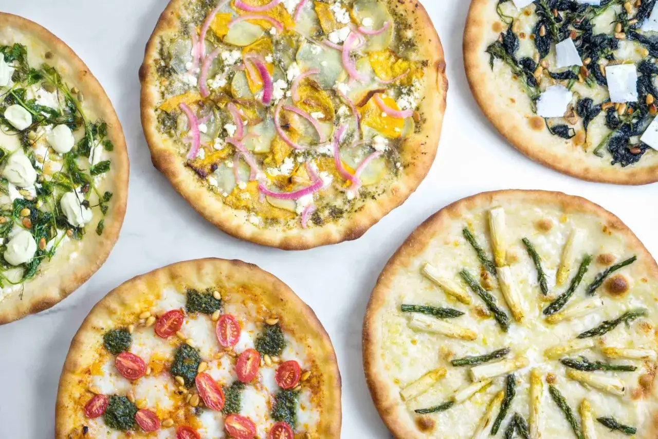 Cinq pizzas aux garnitures vari&eacute;es : asperges, tomates cerises et pesto, &eacute;pinards et pignons, courge et oignons rouges, et une autre avec des l&eacute;gumes verts et de la mozzarella. Une belle id&eacute;e garniture pizza !