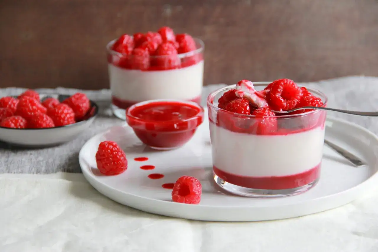 Délicieuse recette panna cotta lait avec coulis de framboises et fruits frais. Un dessert onctueux et fruité.