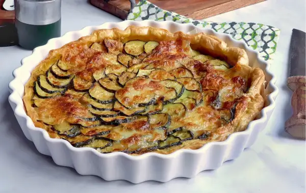 Tarte dorée aux courgettes et mozzarella, prête à être dégustée.